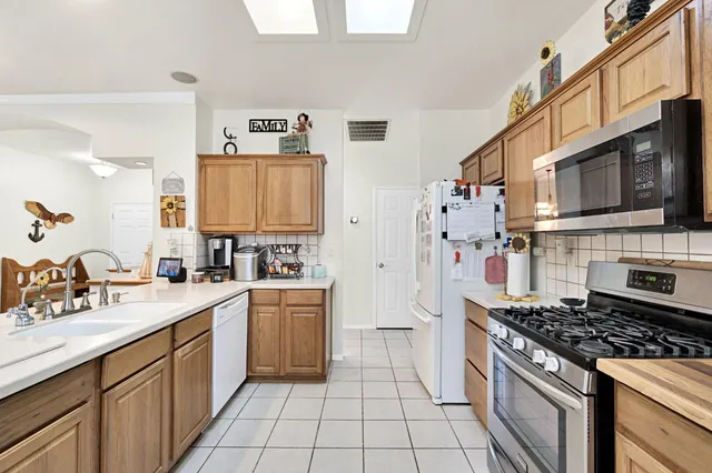 a kitchen with a stove sink and cabinets