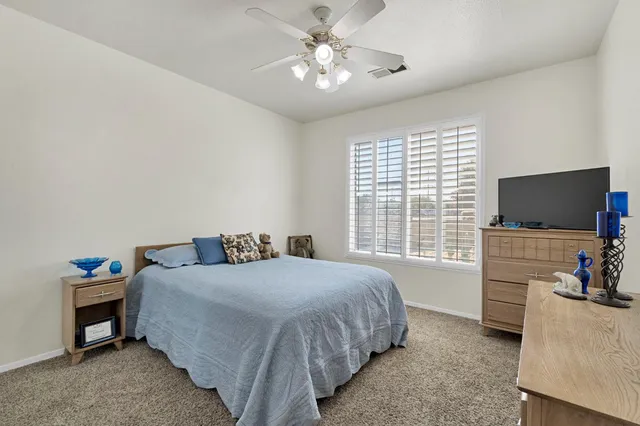 a bedroom with a bed and a flat tv screen on dresser