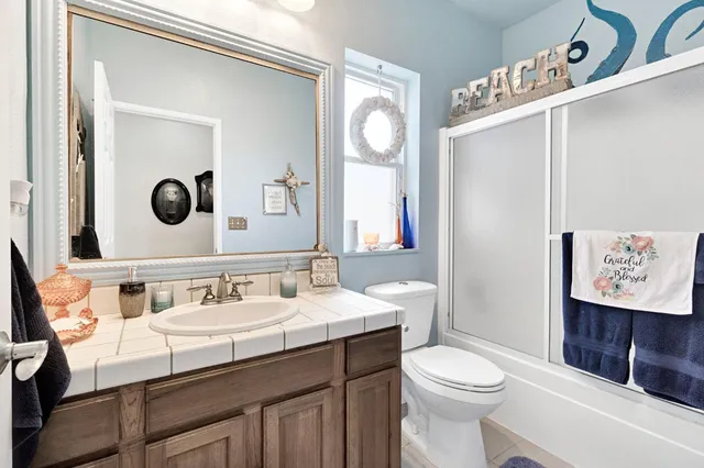 a bathroom with a toilet a sink and mirror