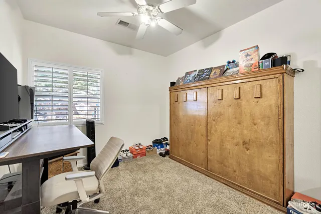 a view of a workspace with furniture and a window