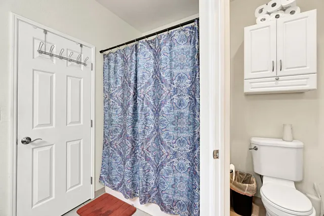 a bathroom with a toilet and a shower