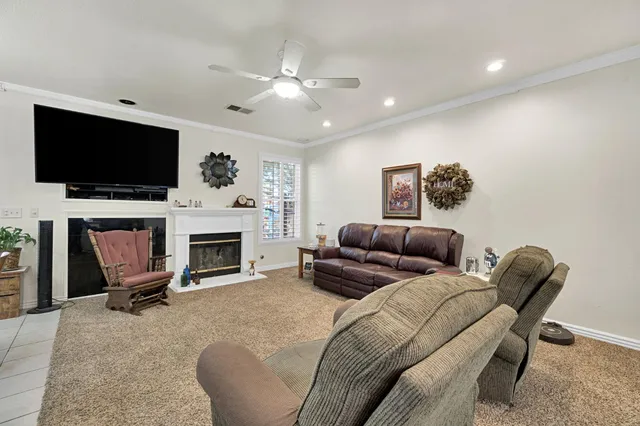 a living room with furniture a fireplace and a flat screen tv
