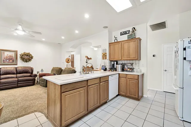 a large white kitchen with a sink and cabinets