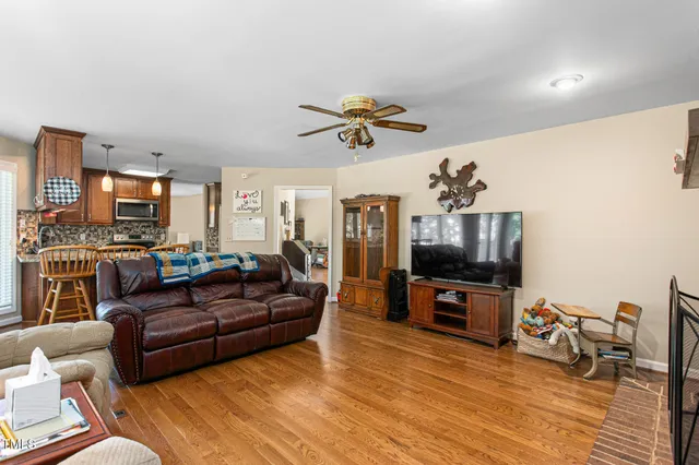 a living room with furniture a flat screen tv and kitchen view