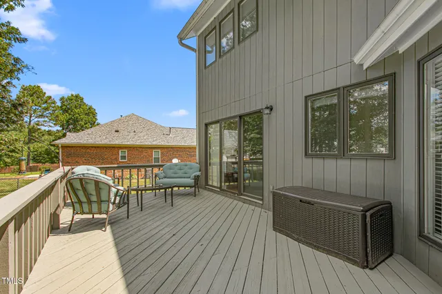 a view of a roof deck with table and chairs with wooden floor and fence