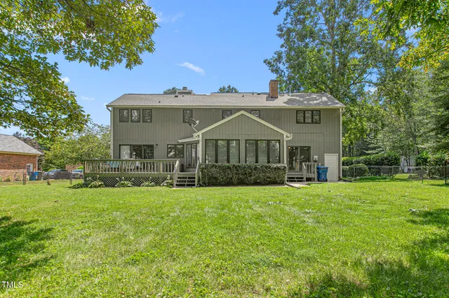 a view of a house with a big yard and large trees