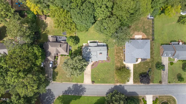 an aerial view of residential houses with outdoor space and trees