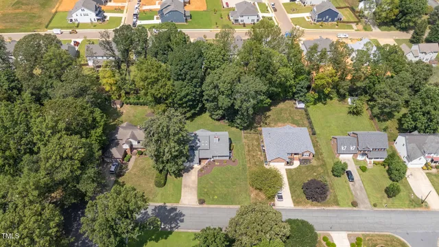 an aerial view of residential house with outdoor space and trees all around