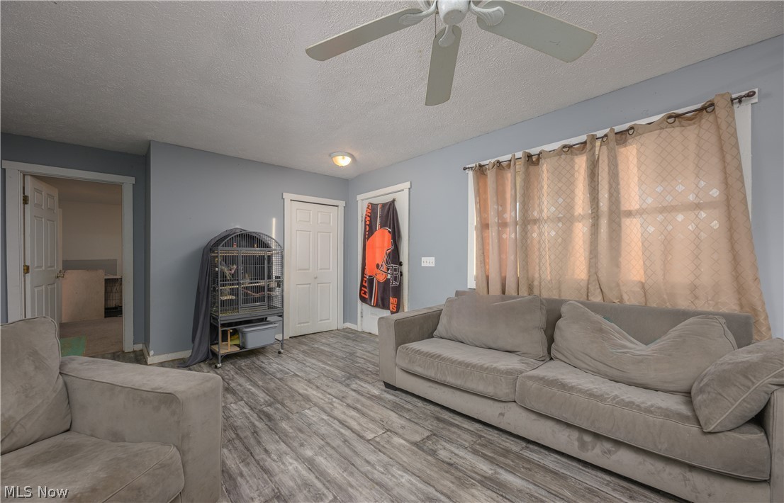 8200 Cutler Road Southwest Sherrodsville, OH 44675 - Photo 13 of 26 Living area with wood finished floors, a ceiling fan, and a textured ceiling