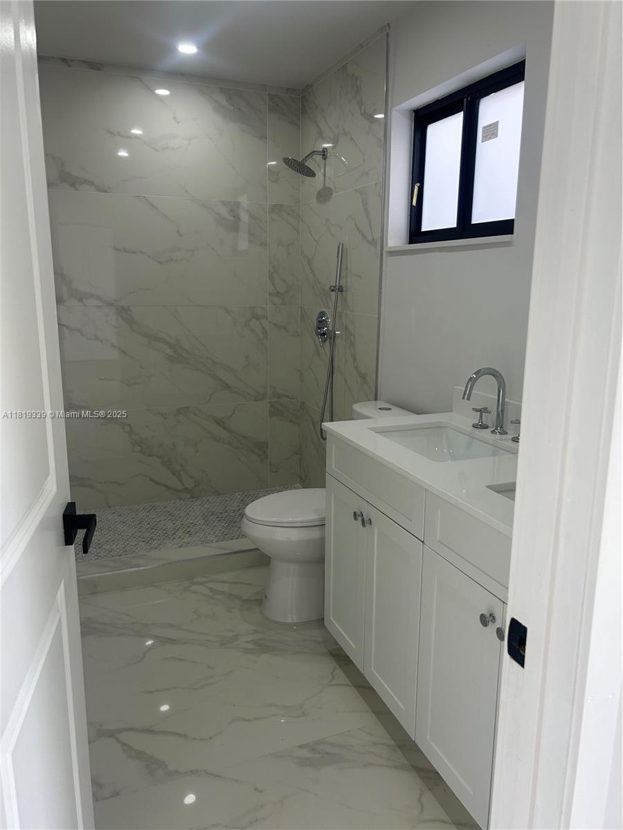 Westchester Miami, FL 33165 - Photo 16 of 25 a bathroom with a granite countertop sink a toilet and shower