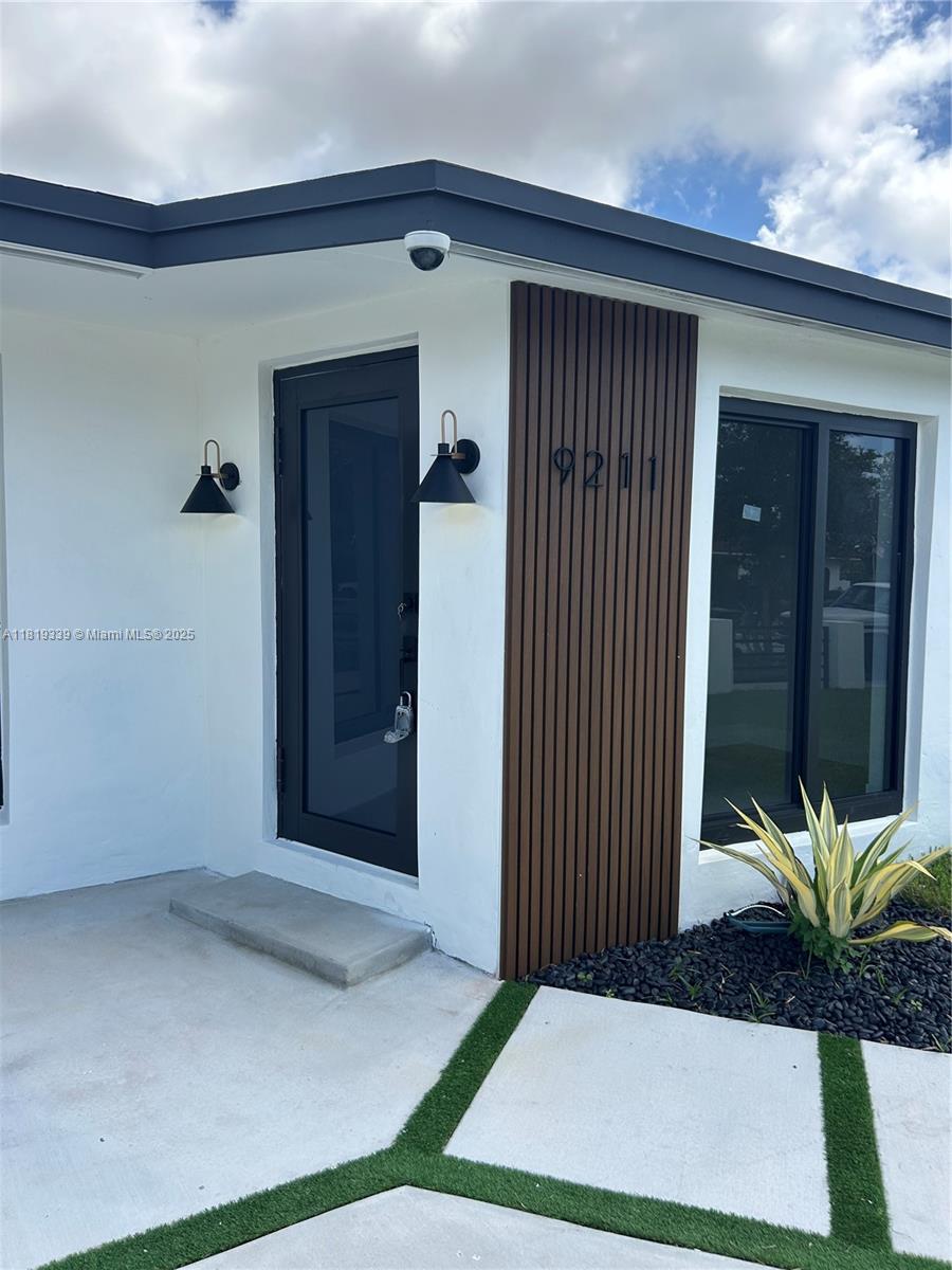 Westchester Miami, FL 33165 - Photo 22 of 25 a view of a porch with a floor to ceiling window and potted plants