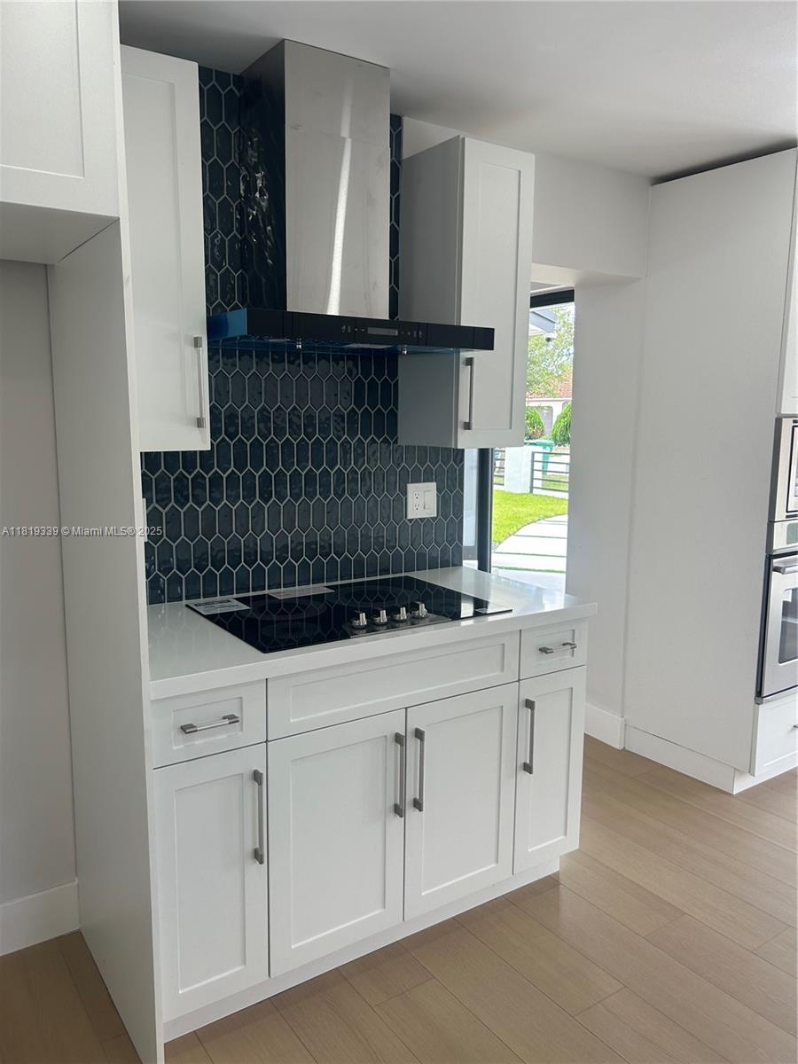 Westchester Miami, FL 33165 - Photo 3 of 25 a kitchen with white cabinets a sink a stove and a window