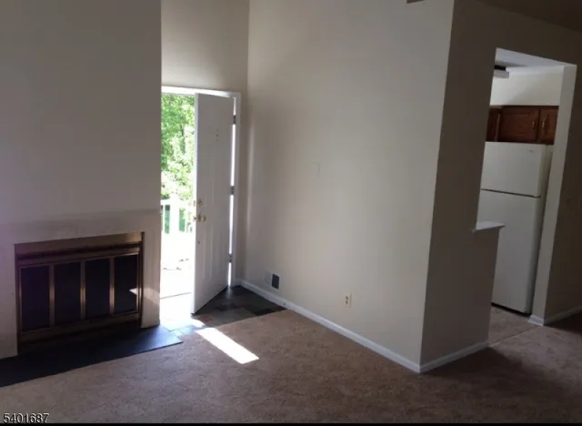 an empty room with windows and fireplace