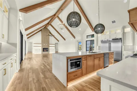 a kitchen with kitchen island a large counter space stainless steel appliances and cabinets