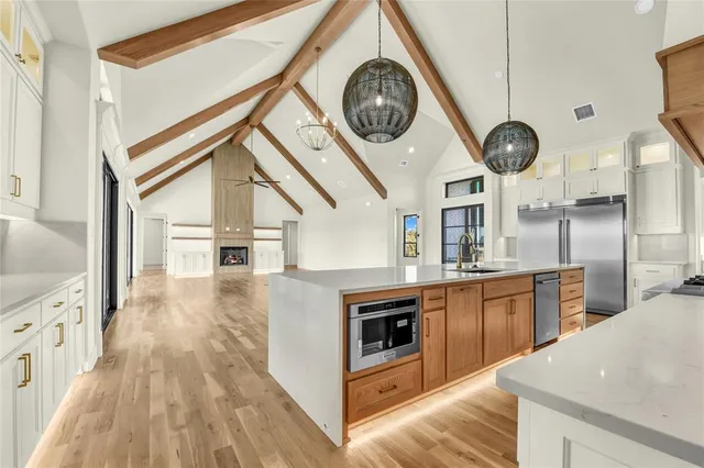 a kitchen with kitchen island a large counter space stainless steel appliances and cabinets