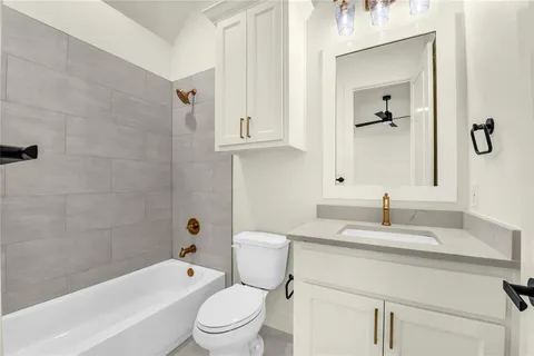 a bathroom with a granite countertop toilet a sink and bathtub