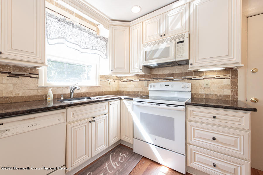 674 Burke Road Jackson, NJ 08527 - Photo 9 of 32 a kitchen with granite countertop white cabinets and white appliances
