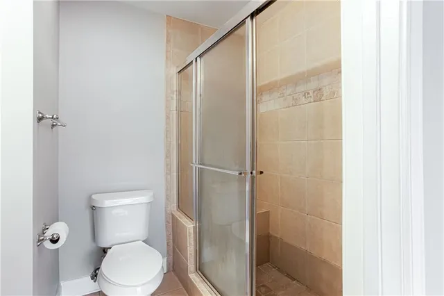 a white toilet sitting next to a shower