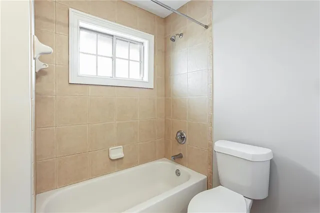 a white toilet sitting next to a bath tub shower
