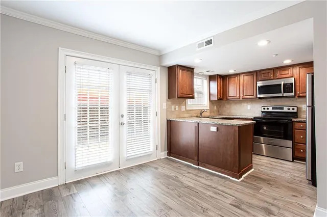 a kitchen with granite countertop a refrigerator stove top oven and sink
