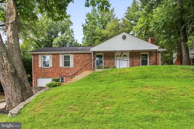 a front view of a house with yard and green space