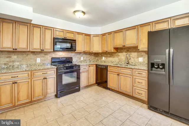 a kitchen with granite countertop a stove top oven sink and cabinets