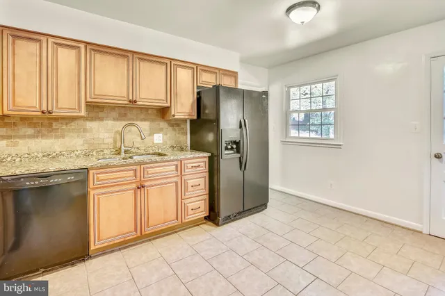 a kitchen with stainless steel appliances granite countertop a refrigerator sink and cabinets