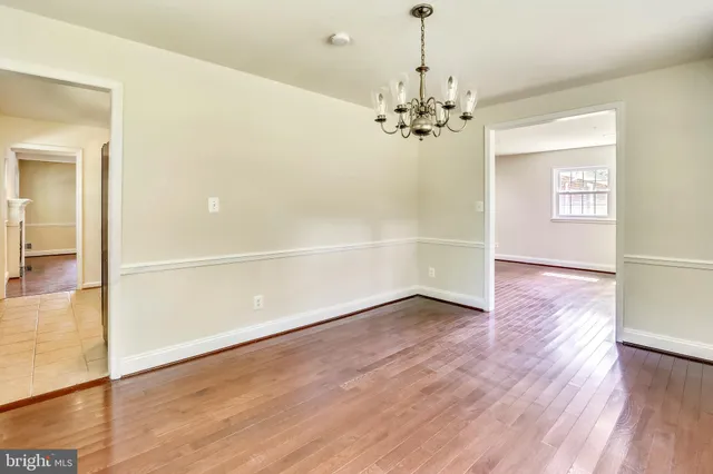 a view of a room with wooden floor chandelier and entryway
