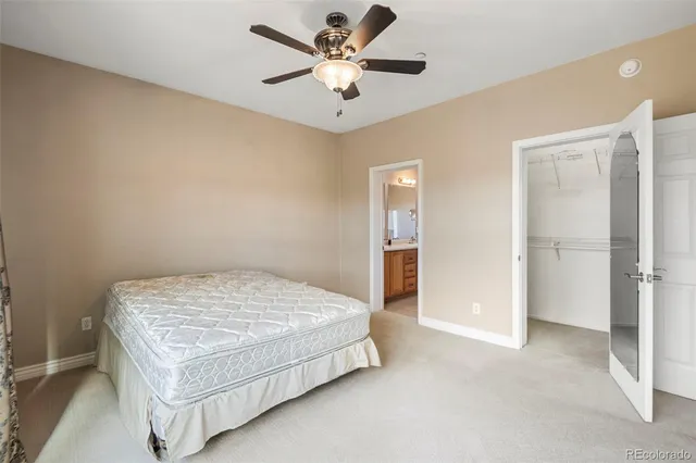 a bedroom with a bed and a ceiling fan