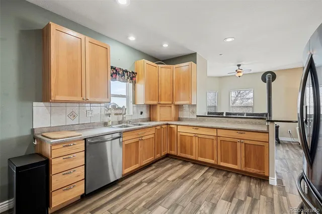 a kitchen with stainless steel appliances granite countertop a sink and cabinets with wooden floor