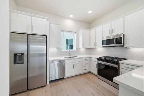 a kitchen with a sink stove and cabinets