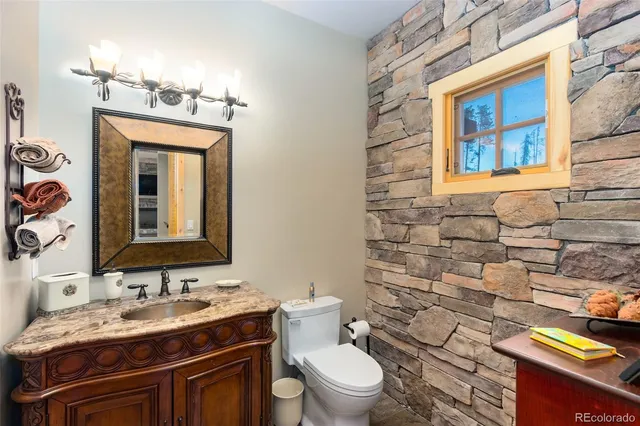a bathroom with a granite countertop toilet sink and mirror
