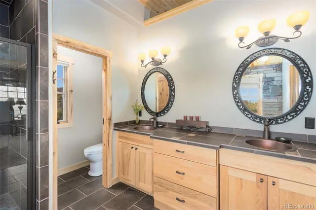 a bathroom with a granite countertop toilet a sink and a mirror