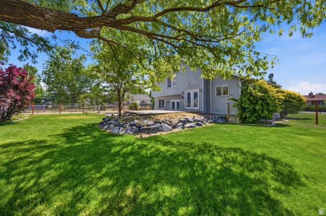 3732 Campbell Road Tooele, UT 84074 - Photo 40 of 69 Expansive green lawn with mature trees and a rock-lined planting area