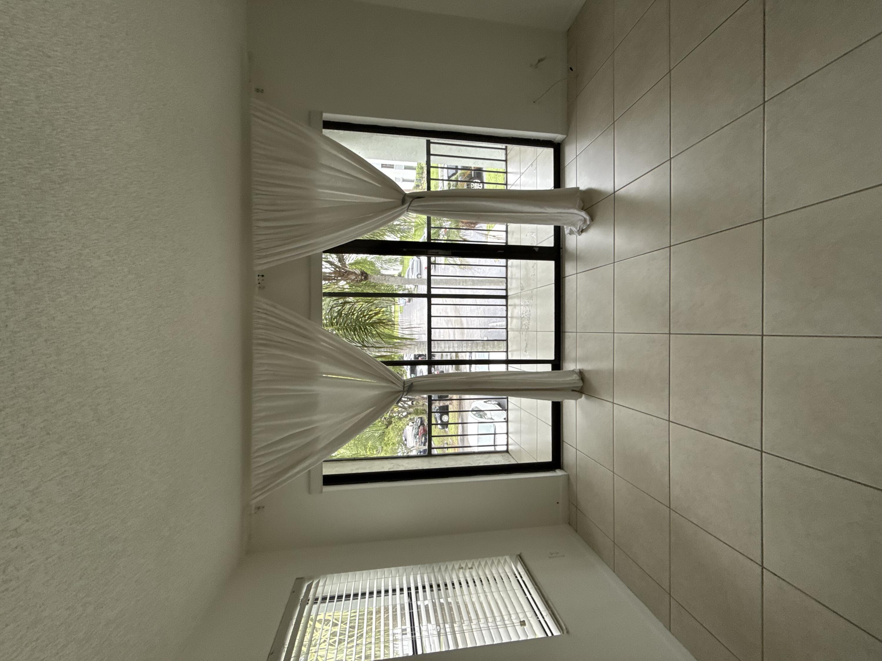 a view of an empty room with a fireplace and a floor to ceiling window