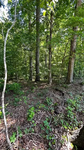 a sign board with a house in the background