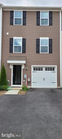 a front view of a building with a yard and garage