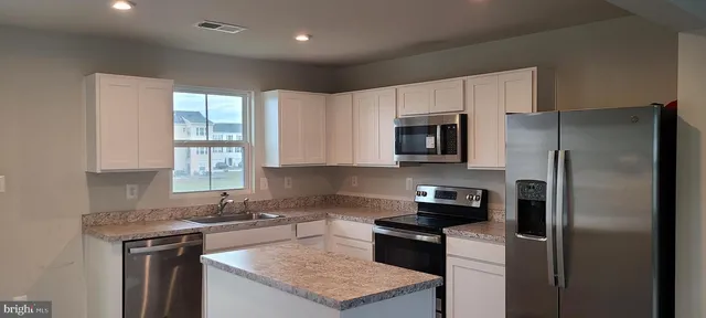 a kitchen with a refrigerator stove and microwave