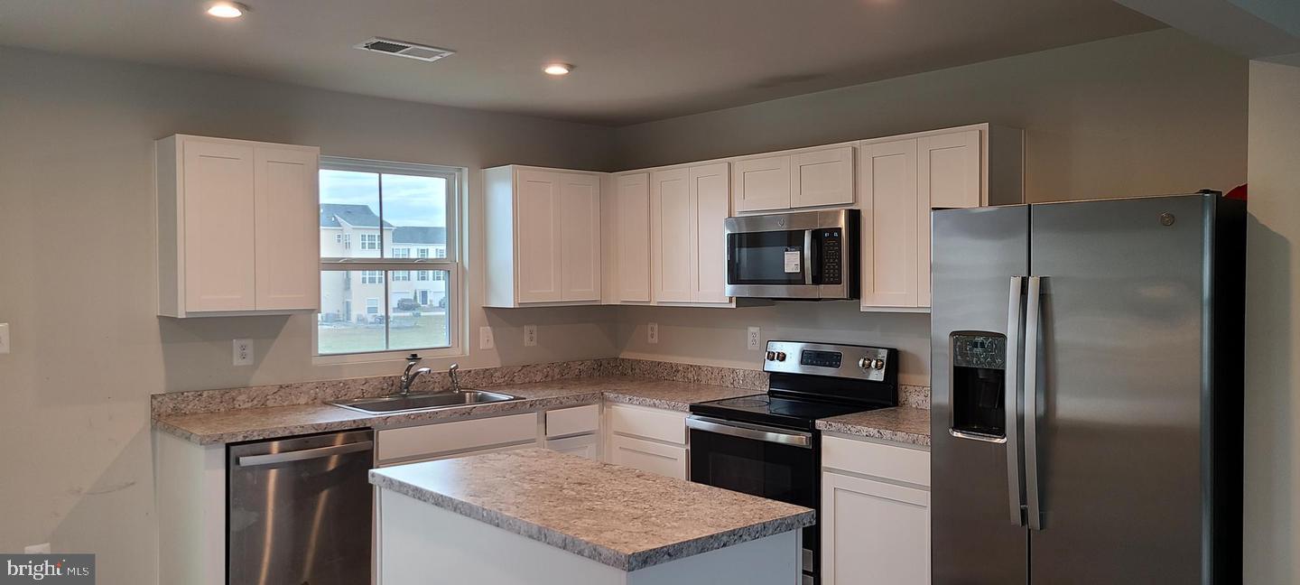 1047 Wickersham Way Middletown, DE 19709 - Photo 2 of 18 a kitchen with a refrigerator stove and microwave