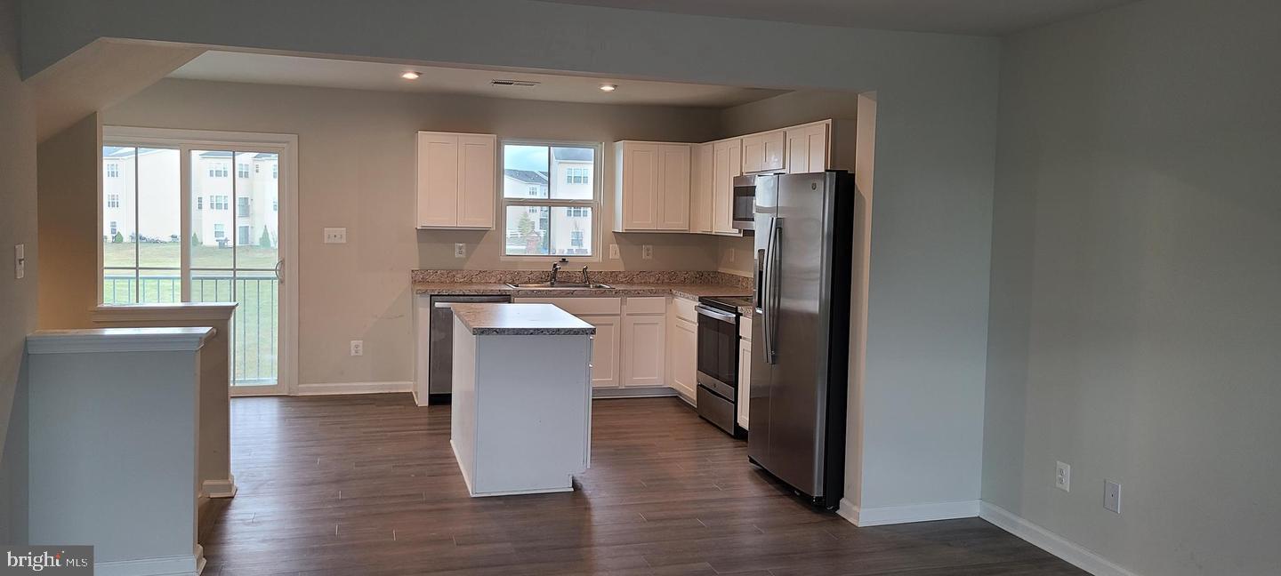 1047 Wickersham Way Middletown, DE 19709 - Photo 4 of 18 a kitchen with stainless steel appliances granite countertop a refrigerator a sink dishwasher a stove with wooden cabinets and wooden floor
