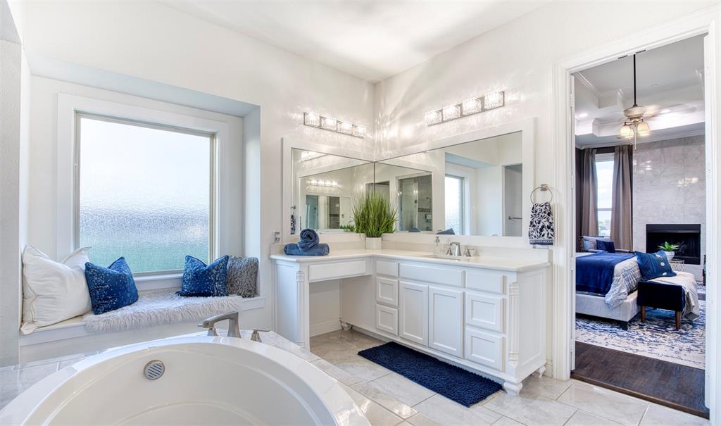901 Inverness Court Lucas, TX 75002 - Photo 22 of 40 Full bath featuring connected bathroom, vanity, a ceiling fan, a large fireplace, and light tile patterned floors