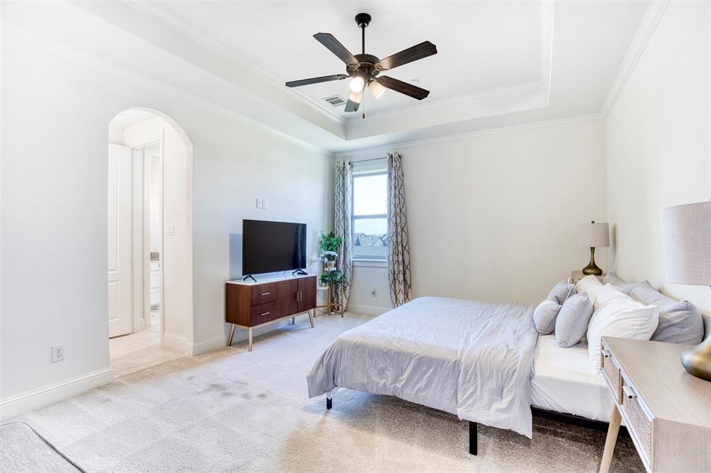 901 Inverness Court Lucas, TX 75002 - Photo 34 of 40 Bedroom featuring arched walkways, light colored carpet, a ceiling fan, a raised ceiling, and ornamental molding