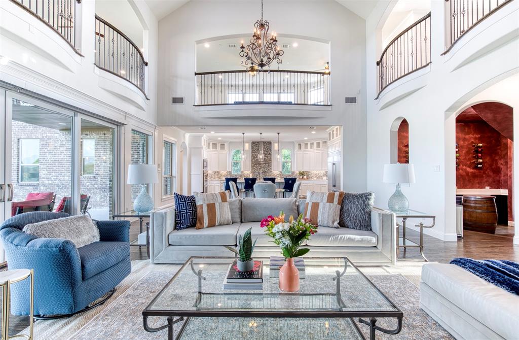 901 Inverness Court Lucas, TX 75002 - Photo 10 of 40 Living room with arched walkways, a chandelier, wood finished floors, and vaulted ceiling