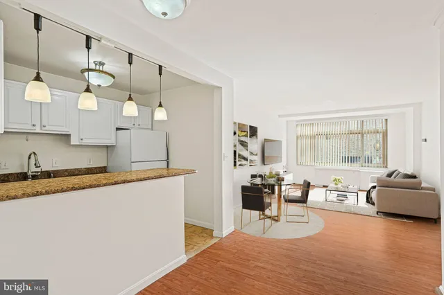 a large living room with granite countertop furniture a rug a stove a sink and a window