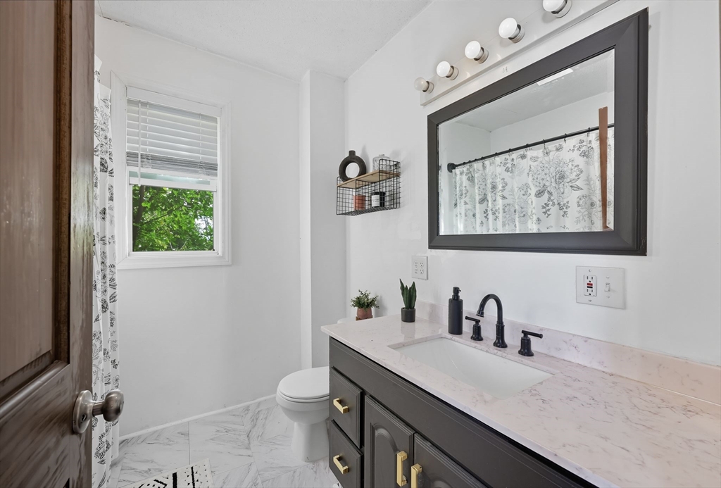 72 Highland Avenue Ludlow, MA 01056 - Photo 28 of 32 a bathroom with a granite countertop sink mirror and toilet