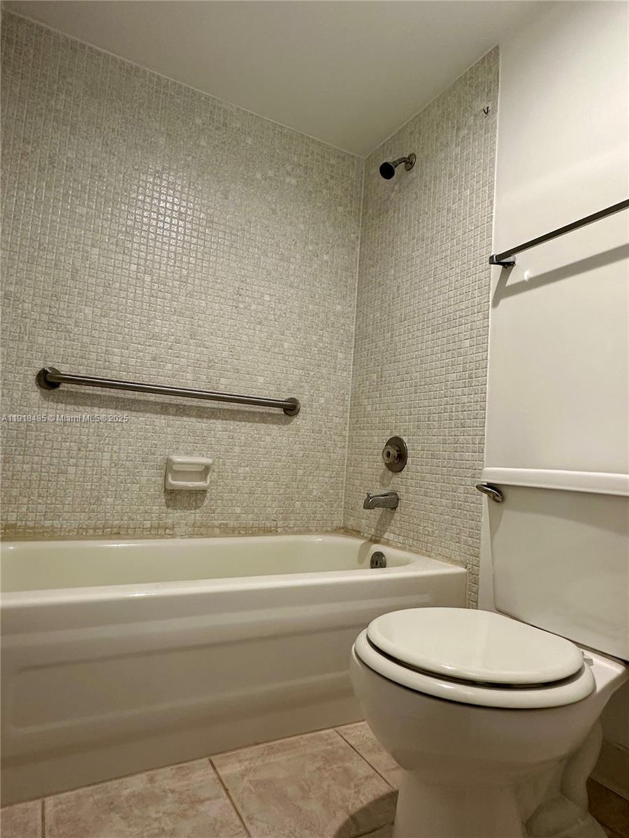 9101 Lime Bay Boulevard, Unit 302 Tamarac, FL 33321 - Photo 24 of 34 a bathroom with a toilet a sink and a bathtub