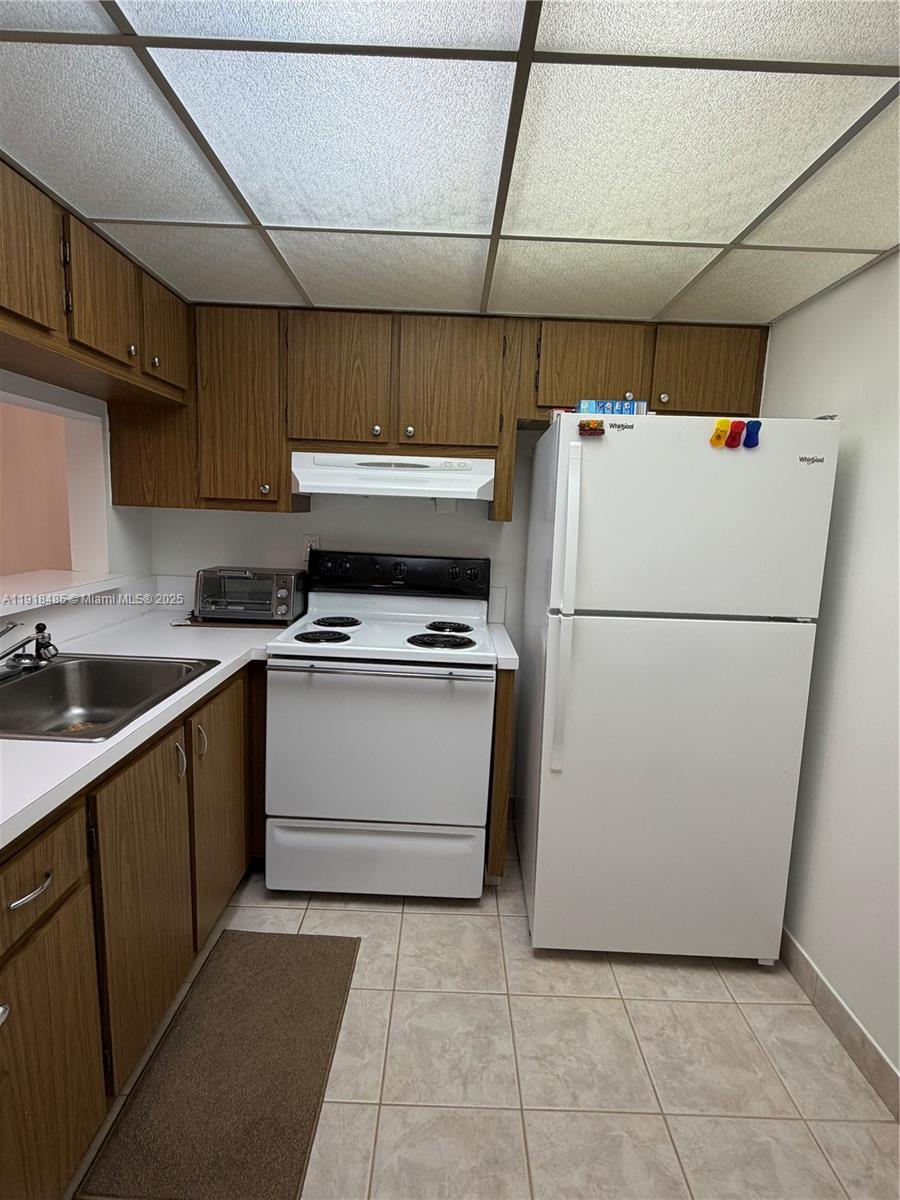 9101 Lime Bay Boulevard, Unit 302 Tamarac, FL 33321 - Photo 28 of 34 a white refrigerator freezer sitting in a kitchen