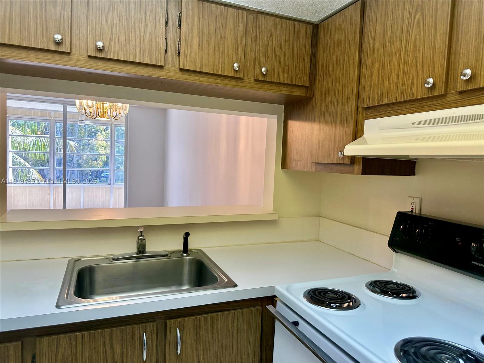 9101 Lime Bay Boulevard, Unit 302 Tamarac, FL 33321 - Photo 5 of 34 a kitchen with a sink and a stove top oven