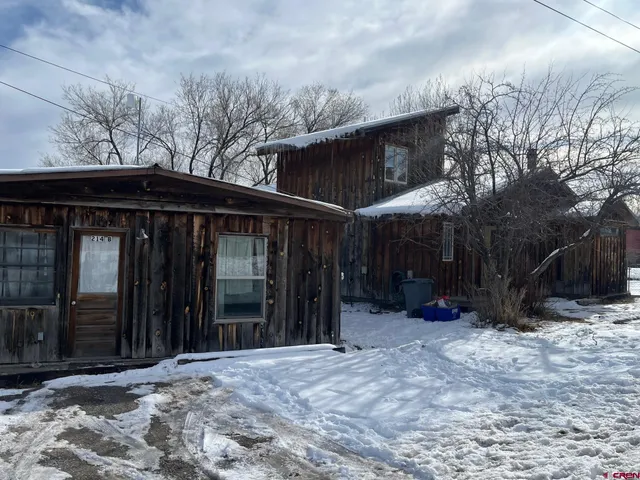a view of a house with a yard covered in snow