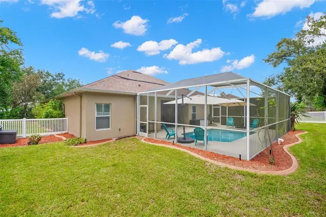 a view of a white house with a swimming pool and a yard